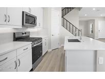 Modern kitchen with stainless steel appliances and white cabinets at 4923 E Village Dr, Scottsdale, AZ 85254