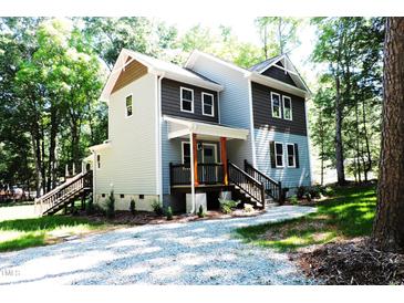 Two-story house with gray and brown siding, front porch, and stairs at 7647 Cummings Dr, Mebane, NC 27302