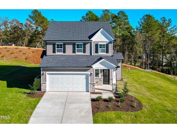 Two-story house with gray siding, white garage door, and landscaped yard at 141 Beacon Hill Rd # 13, Lillington, NC 27546