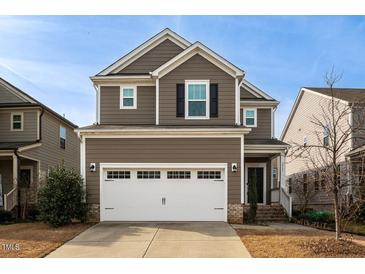 Two-story brown house with white garage door and brick accents at 2921 Macbeth Ln, Apex, NC 27502