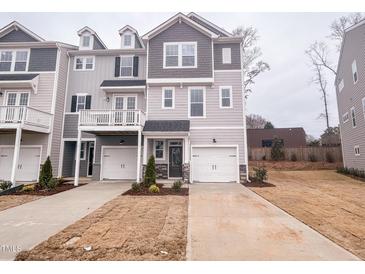 Two-story townhome with gray siding, two-car garage, and small front yard at 127 Sugar Run Dr # 27, Fuquay Varina, NC 27526