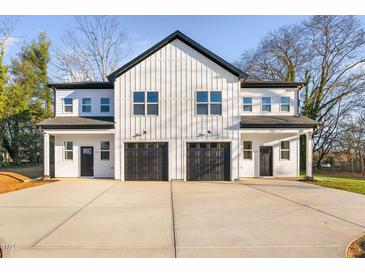 Two-unit modern farmhouse with attached garages and concrete driveway at 331 Roxboro St, Haw River, NC 27258
