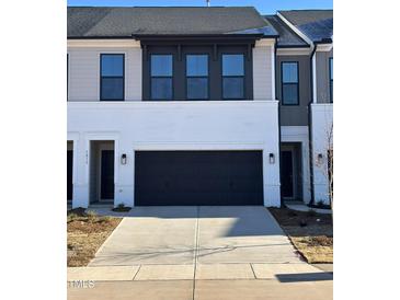 Modern two-story townhome with gray and white exterior, two-car garage, and landscaping at 1015 Westerland Way # 53, Durham, NC 27703