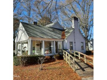Charming white home with a sunroom, wooden ramp, and landscaping at 1852 Nc 62 Hwy N, Burlington, NC 27217