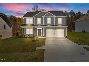 Two-story house with gray siding, white garage door, and landscaped lawn at 530 Husketh Rd, Youngsville, NC 27596