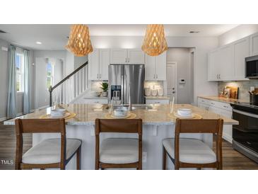 Modern kitchen with large island, stainless steel appliances, and granite countertops at 156 Pinkie Ln, Garner, NC 27529