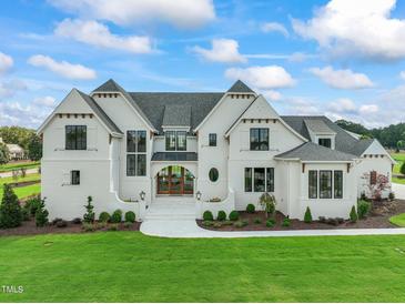 Two-story white brick home with gray roof and landscaping at 8916 Grand Highland Way, Wake Forest, NC 27587