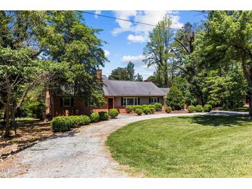 Brick ranch home with a large lawn and driveway at 222 Lake Shore Dr, Roxboro, NC 27573