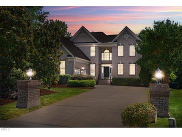 Two story brick home with a large driveway and mature landscaping at 11603 Broadfield Ct, Raleigh, NC 27617