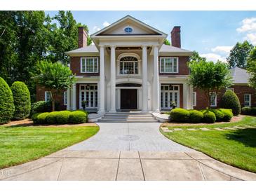 Impressive two-story home with a grand entrance, brick facade, and manicured landscaping at 1820 Oatlands Court Ct, Wake Forest, NC 27587