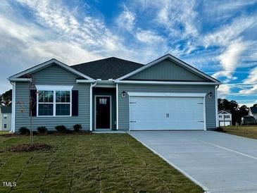 Gray exterior of charming one-story house with two car garage and manicured lawn at 7565 Michelle Rd, Rocky Mount, NC 27803