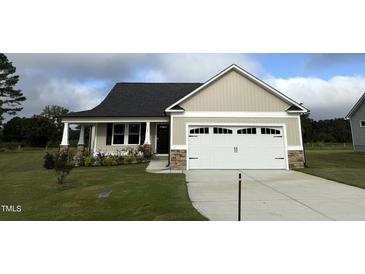 Tan house with a two-car garage and landscaping at 158 Scotties Ridge Dr, Princeton, NC 27569