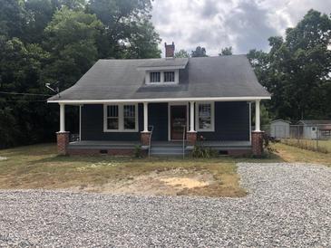 Charming one-story home with a spacious front porch and gravel driveway at 3124 Raleigh Rd, Henderson, NC 27537