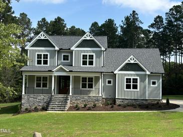 Two-story home with gray siding and stone accents at 200 Whistlers Cv, Louisburg, NC 27549