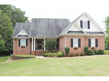 Brick home with a large front yard and landscaping at 3331 Lazy Ln, Graham, NC 27253