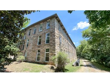 Stone building with multiple windows and a tree-lined path at 1500 River Mill Drive Dr # 110, Wake Forest, NC 27587