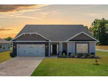 Charming single-story home with a welcoming front yard and attached garage at 87 S Cousins Ct, Smithfield, NC 27577