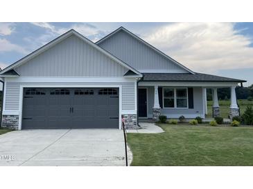 Two-car garage and front yard of a craftsman style home at 46 Scotties Ridge Dr, Princeton, NC 27569