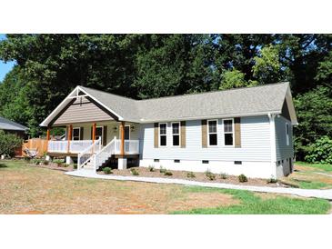 Charming one-story home with a covered porch and landscaped yard at 513 N Carr St, Mebane, NC 27302