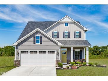 Two-story house with gray siding, landscaping, and two-car garage at 8916 Stratus St, Willow Springs, NC 27592