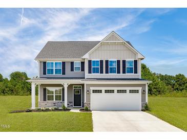 Two story house with gray siding, white trim and two-car garage at 8813 Tartan Clan Dr, Willow Springs, NC 27592