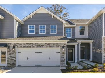 Two-story townhome with gray siding, stone accents, and a two-car garage at 2238 Cherry Top Dr, Fuquay Varina, NC 27526