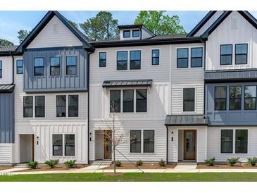 Modern three-story townhouses with white and blue siding at 6408 Tanner Oak Ln, Raleigh, NC 27613