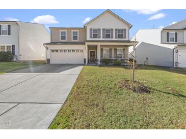 Two-story house with a beige exterior, a large front yard, and a two-car garage at 4301 Auburn Hills Dr, Raleigh, NC 27616