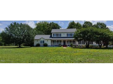 Two-story house with a large front yard, featuring a spacious porch and mature trees at 1525 Marshburn Rd, Wendell, NC 27591