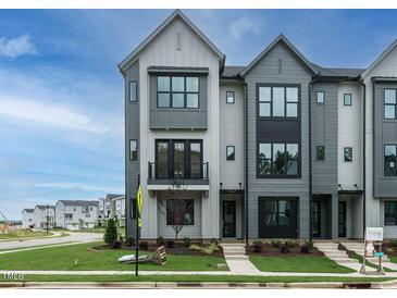 Modern three-story townhome with gray siding, black windows, and a front porch at 1140 Cottonsprings Dr, Wendell, NC 27591