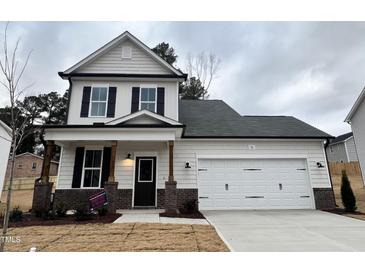 Two-story house with white siding, dark trim, and a two-car garage at 36 Fetterbush Way, Clayton, NC 27520