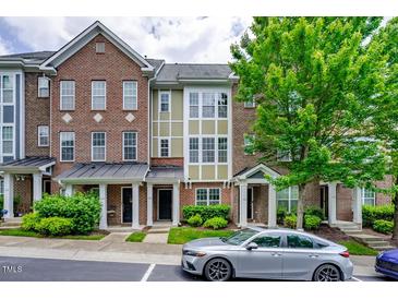 Brick townhome with 3 levels, front porch, and landscaping at 128 Dove Cottage Ln, Cary, NC 27519
