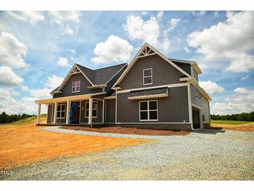 Gray farmhouse-style home with a gravel driveway and large yard at 6030 Preacher Hayes Rd, Mebane, NC 27302