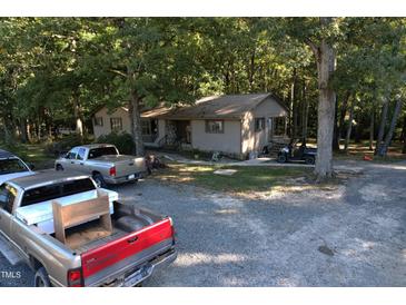 Single story home exterior surrounded by trees at 1612 Us 64, Apex, NC 27523