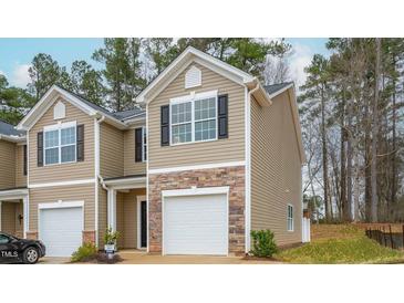 Tan two-story townhome with a white garage door and stone accents at 2833 Egert Dr, Haw River, NC 27258