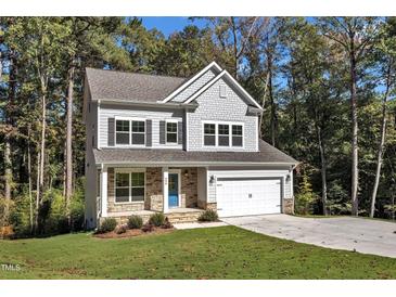 Two-story house with gray siding, stone accents, and a two-car garage at 900 Sw Maynard Rd, Cary, NC 27511