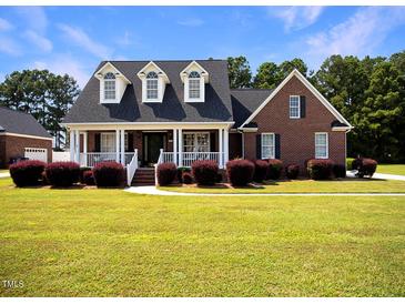 Brick home with a front porch and well-manicured lawn at 107 Knottingham Ct, Dunn, NC 28334