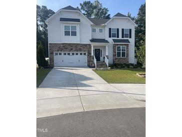 Two-story house with white siding, stone accents, and a three-car garage at 5011 Manderleigh Dr, Knightdale, NC 27545