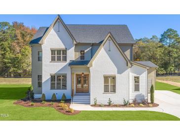 Two-story house with white brick and a gray roof at 212 Meadow Walk Dr, Fuquay Varina, NC 27526