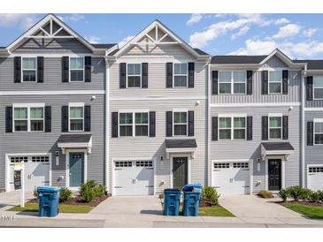 Three-story townhouses with gray siding and two-car garages at 1109 Pale Moss Dr, Durham, NC 27704