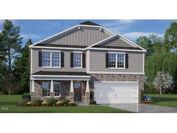 Two-story home with stone and siding exterior, two-car garage and landscaping at 6421 Alfalfa Ln, Wake Forest, NC 27587