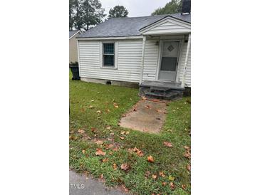 White single story home with steps leading to front door and small front yard at 110 W Grady St, Four Oaks, NC 27524