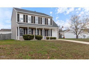 Two-story house with a light brown facade, a front porch, and a well-maintained lawn at 3008 Twinfield Ct, Raleigh, NC 27610