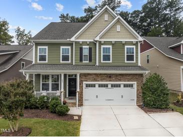 Two-story house with green siding, stone accents, and a two-car garage at 609 Meadowgrass Ln, Wake Forest, NC 27587