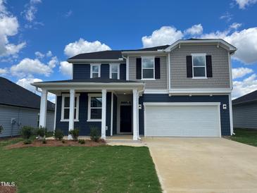 Two-story home with gray and blue siding, a white garage door, and a landscaped lawn at 126 Norman Ave, Lillington, NC 27546