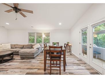 Spacious living room features a comfortable sectional sofa and adjacent dining area with access to deck at 308 Trimble Ave, Cary, NC 27511