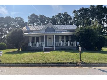 Charming one-story home with a front porch and a well-maintained lawn at 409 W Main St, Spring Hope, NC 27882