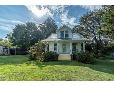 White house with metal roof and large yard at 359 Trollingwood Rd, Haw River, NC 27258