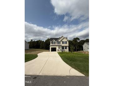 Two-story house with beige siding, black windows, and a concrete driveway at 153 Wynd Crest Way, Benson, NC 27504