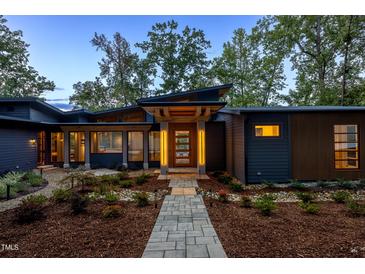 Modern home exterior with a lighted walkway and landscaping at 23930 Cherry, Chapel Hill, NC 27517